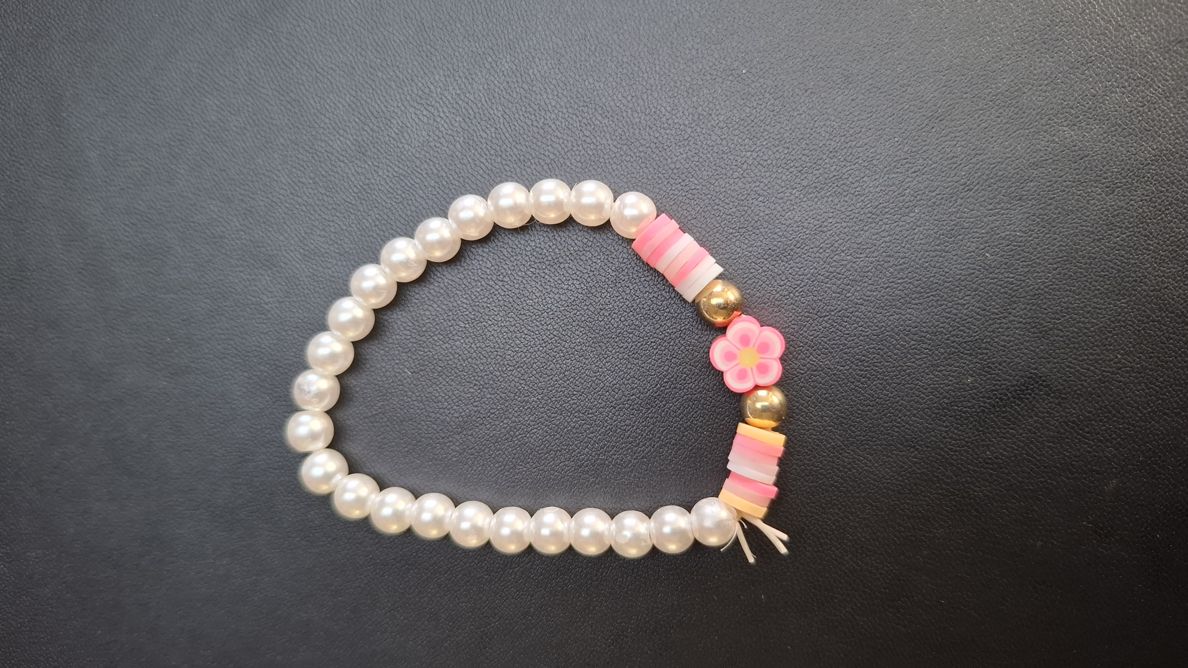 armband roze/wit/paars met witte kralen en roze bloem
