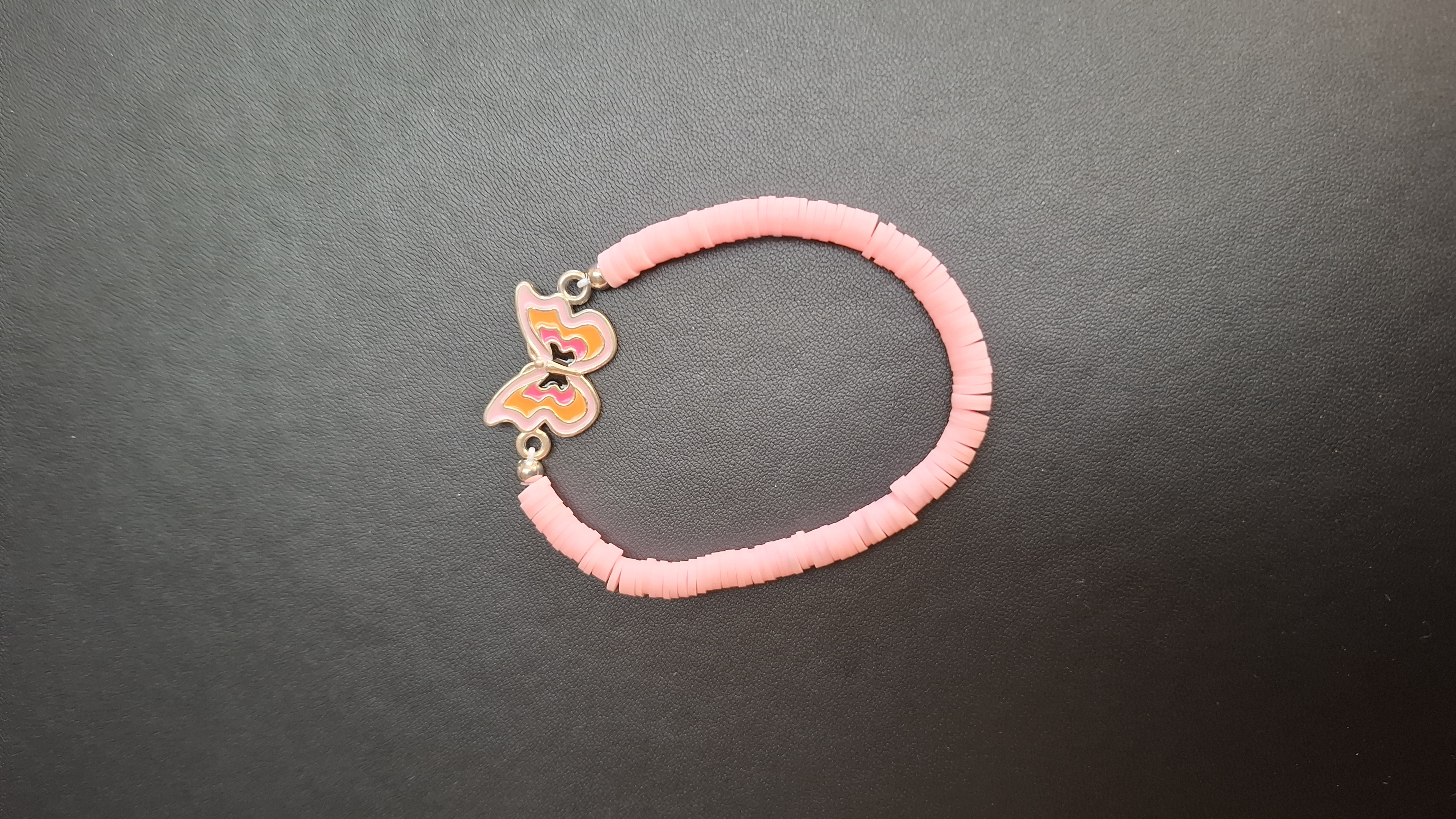 armband roze met oranje vlinder