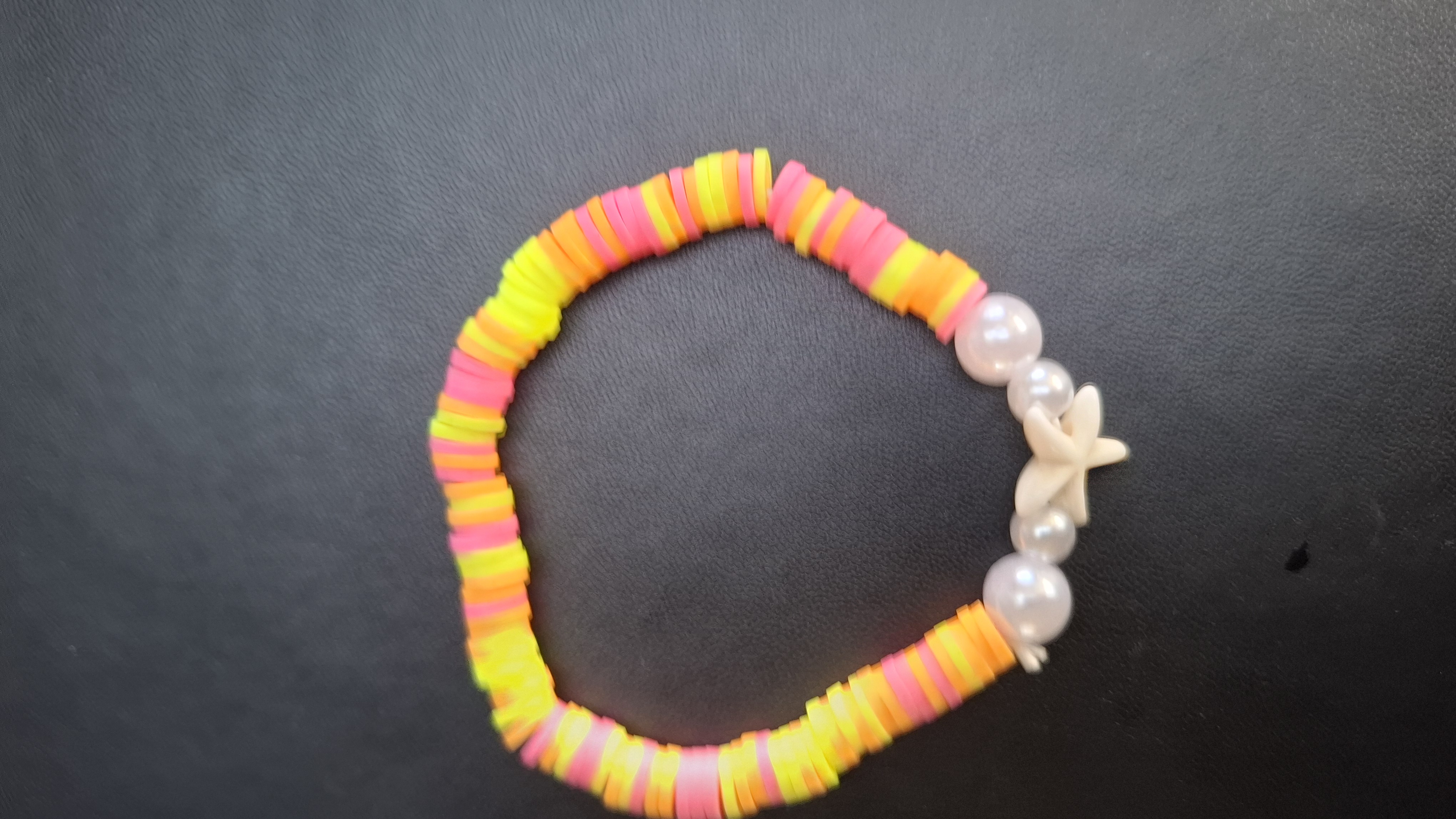 armband geel/roze/oranje met 4 witte kralen en zeester