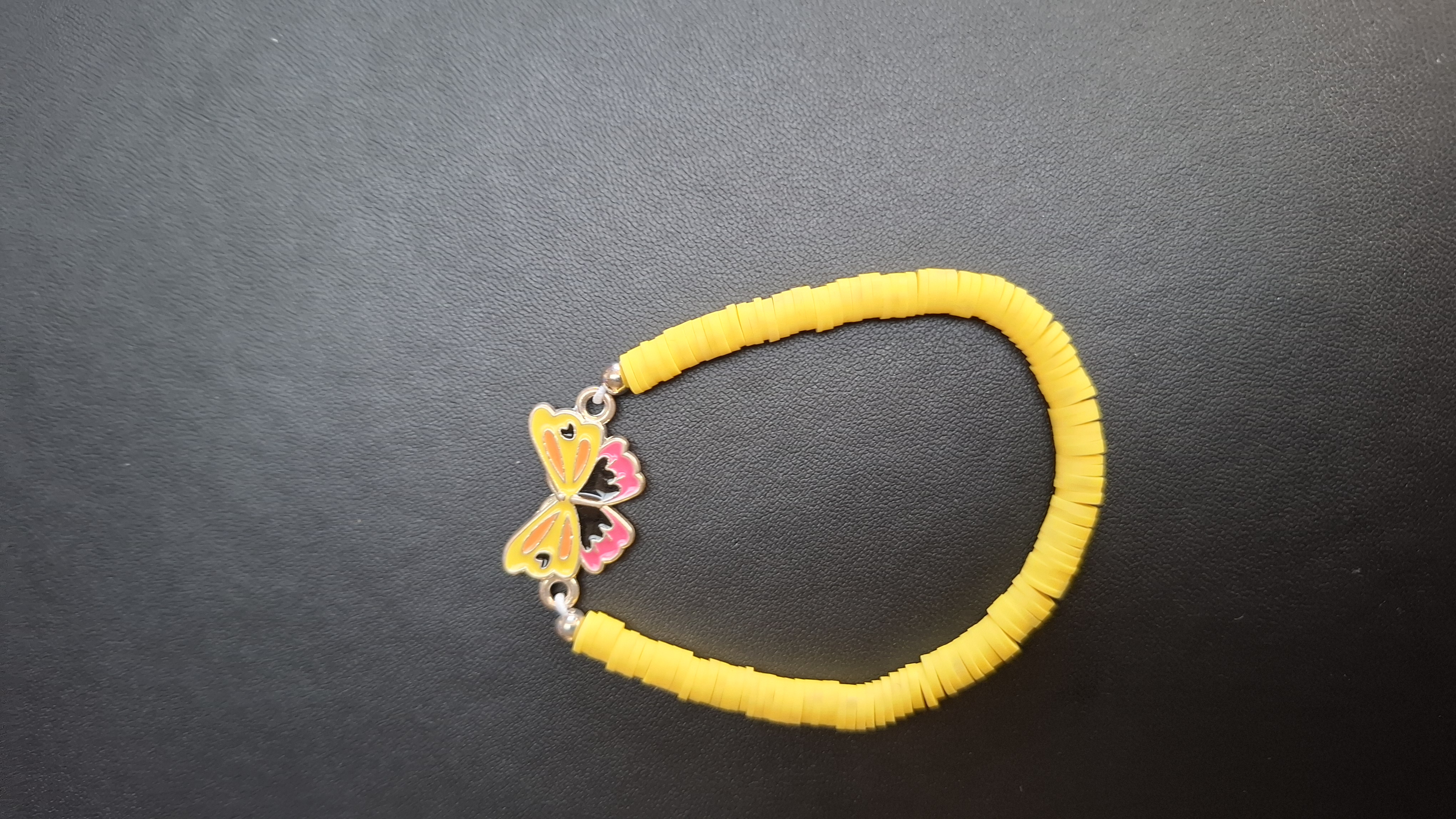 armband geel met geel/roze vlinder