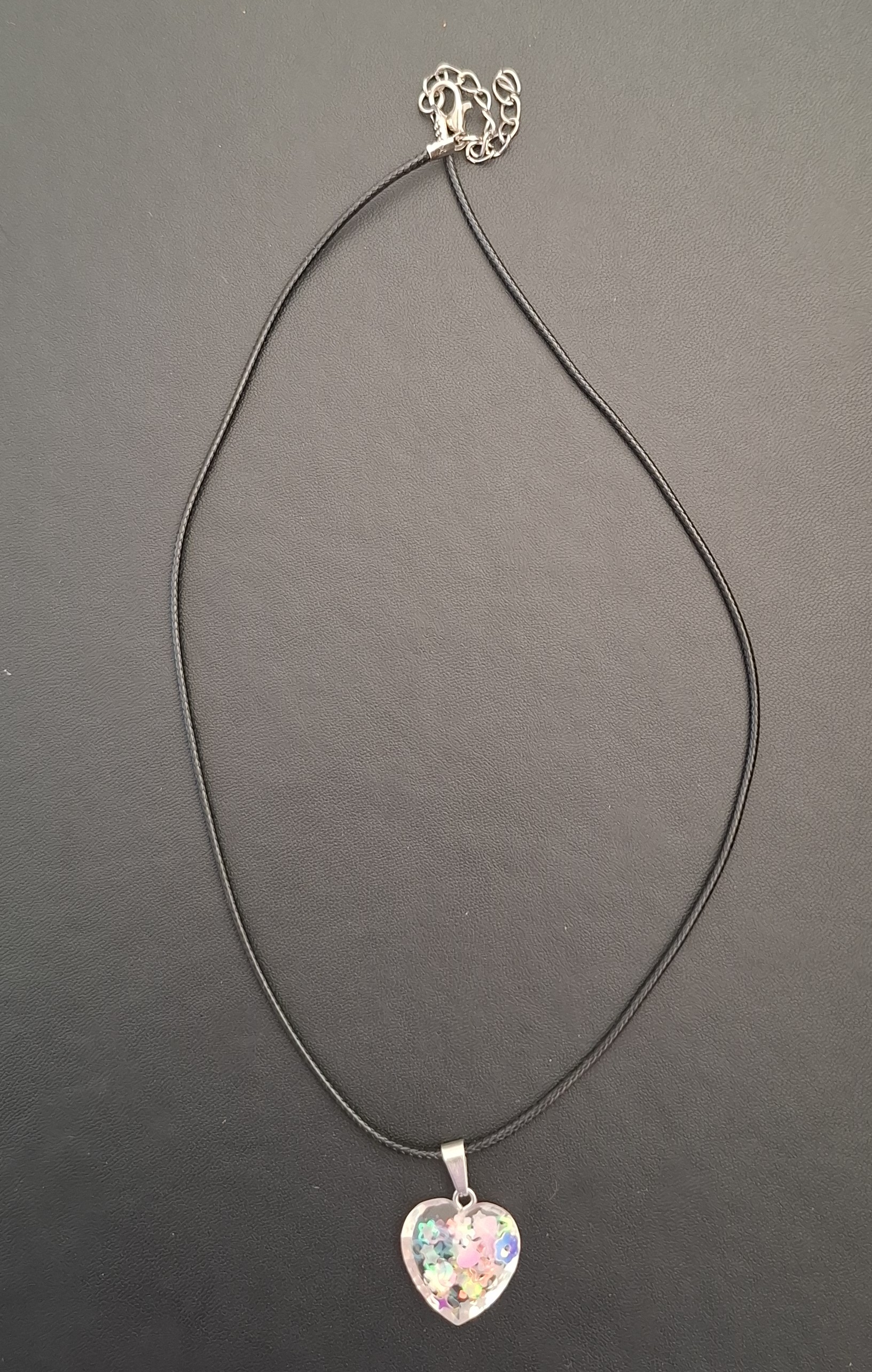 zwarte kunststof ketting met hartje met diverse kleuren erin