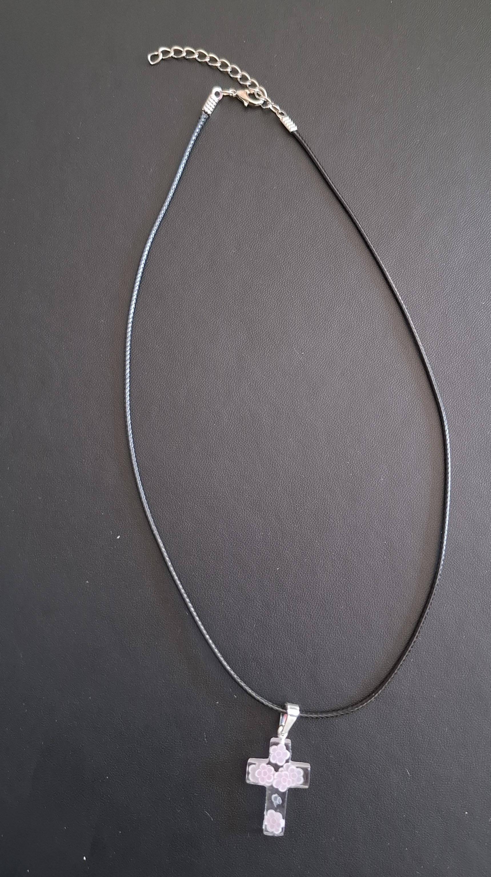zwarte kunststof ketting met doorzichtig kruis met wit/lila bloemetjes