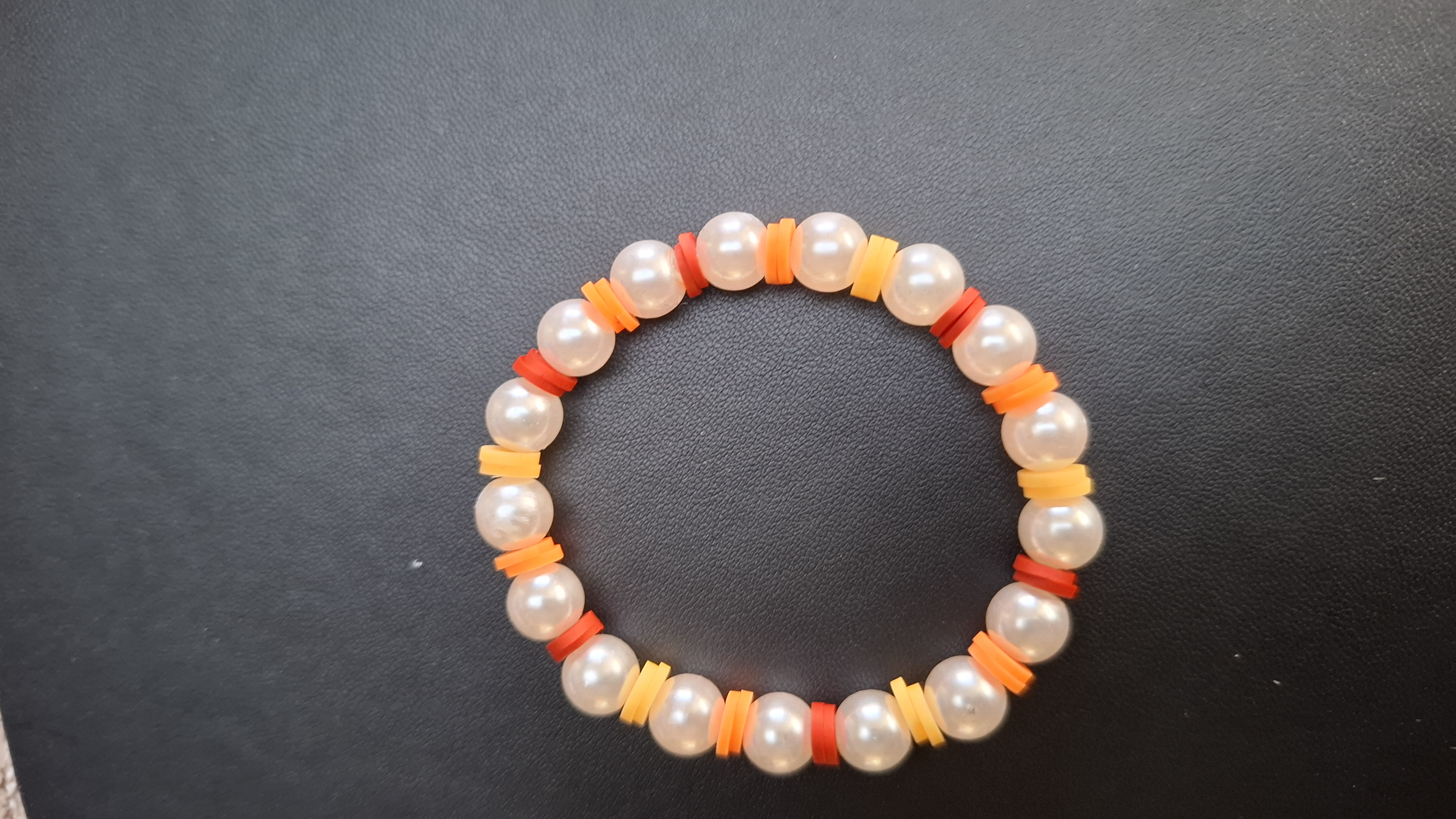 armband geel/oranje/rood met creme kralen