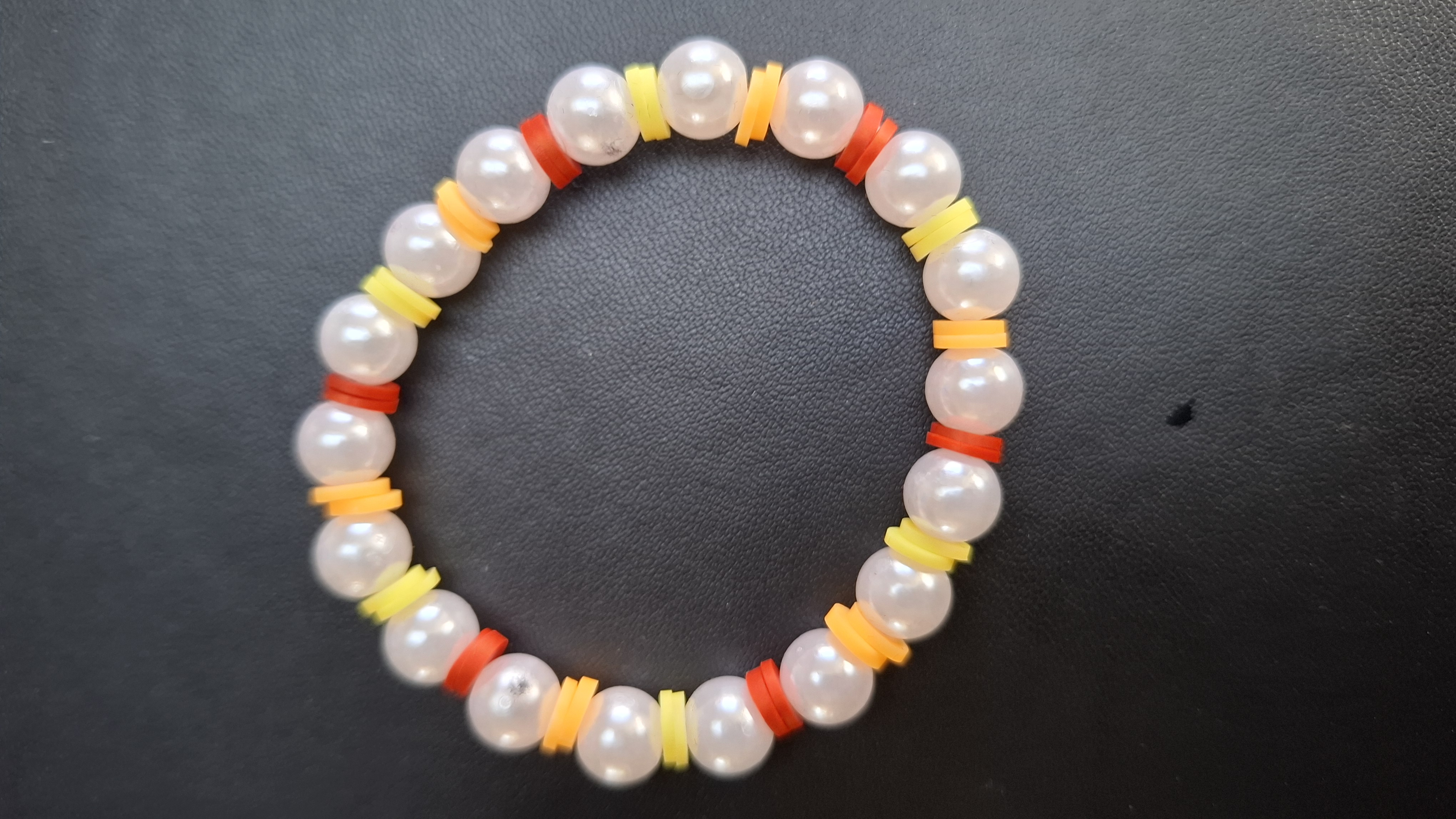 armband geel/oranje/rood met witte kralen
