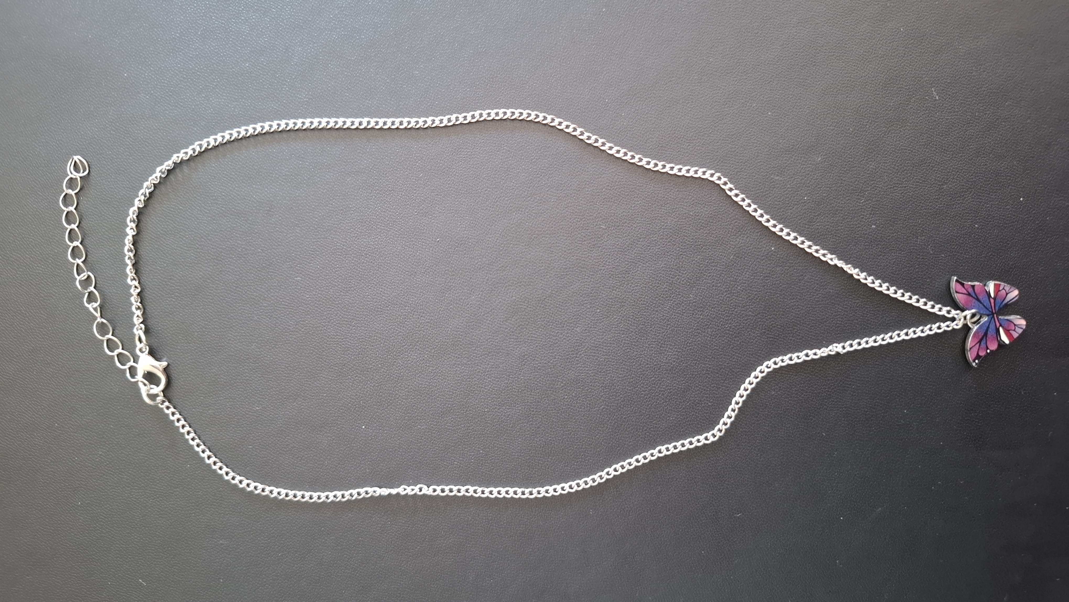 ketting in zilveren kleur met roze/paarse vlinder