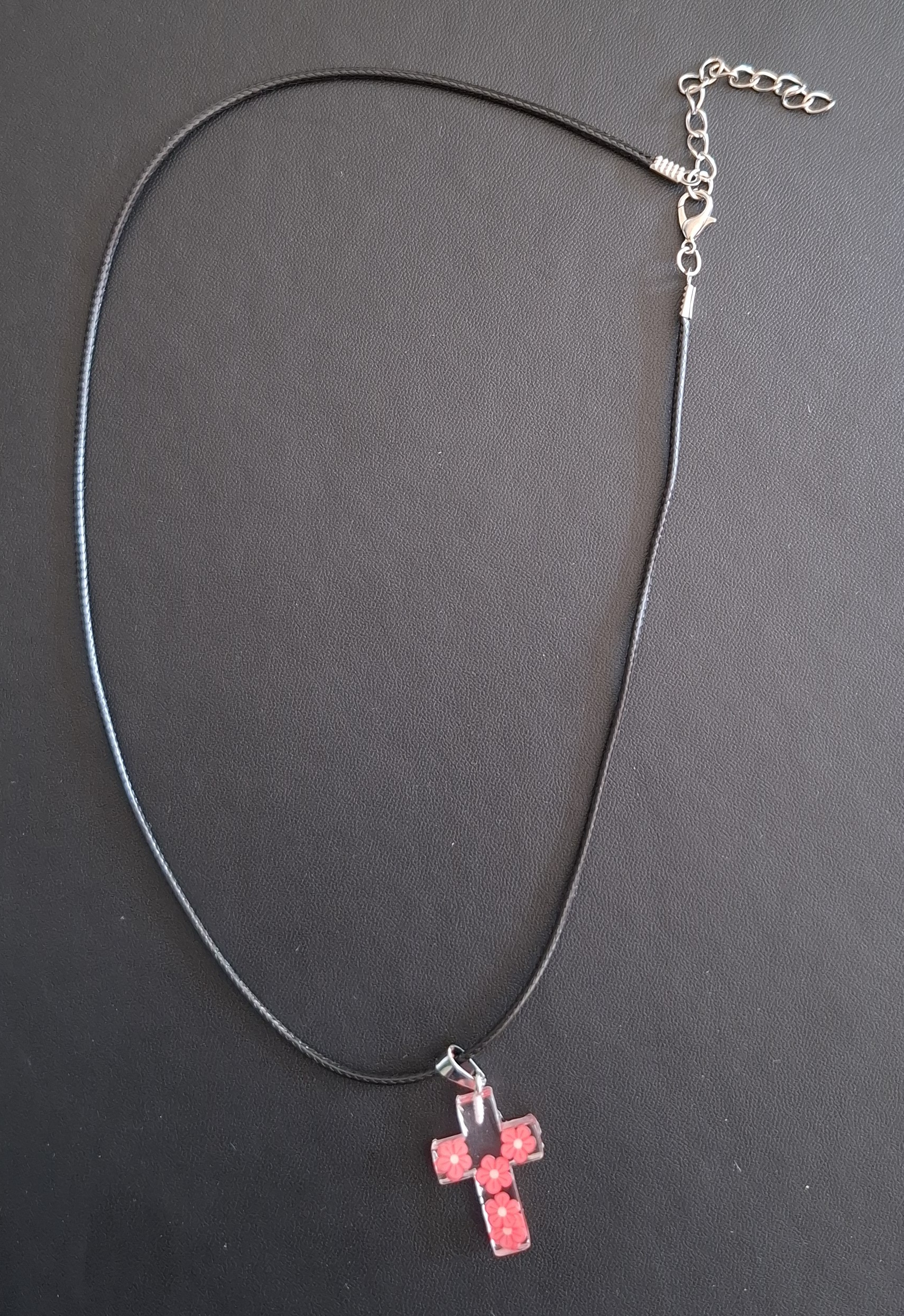 zwarte kunststof ketting met doorzichtig kruis met rose/rode bloemetjes 