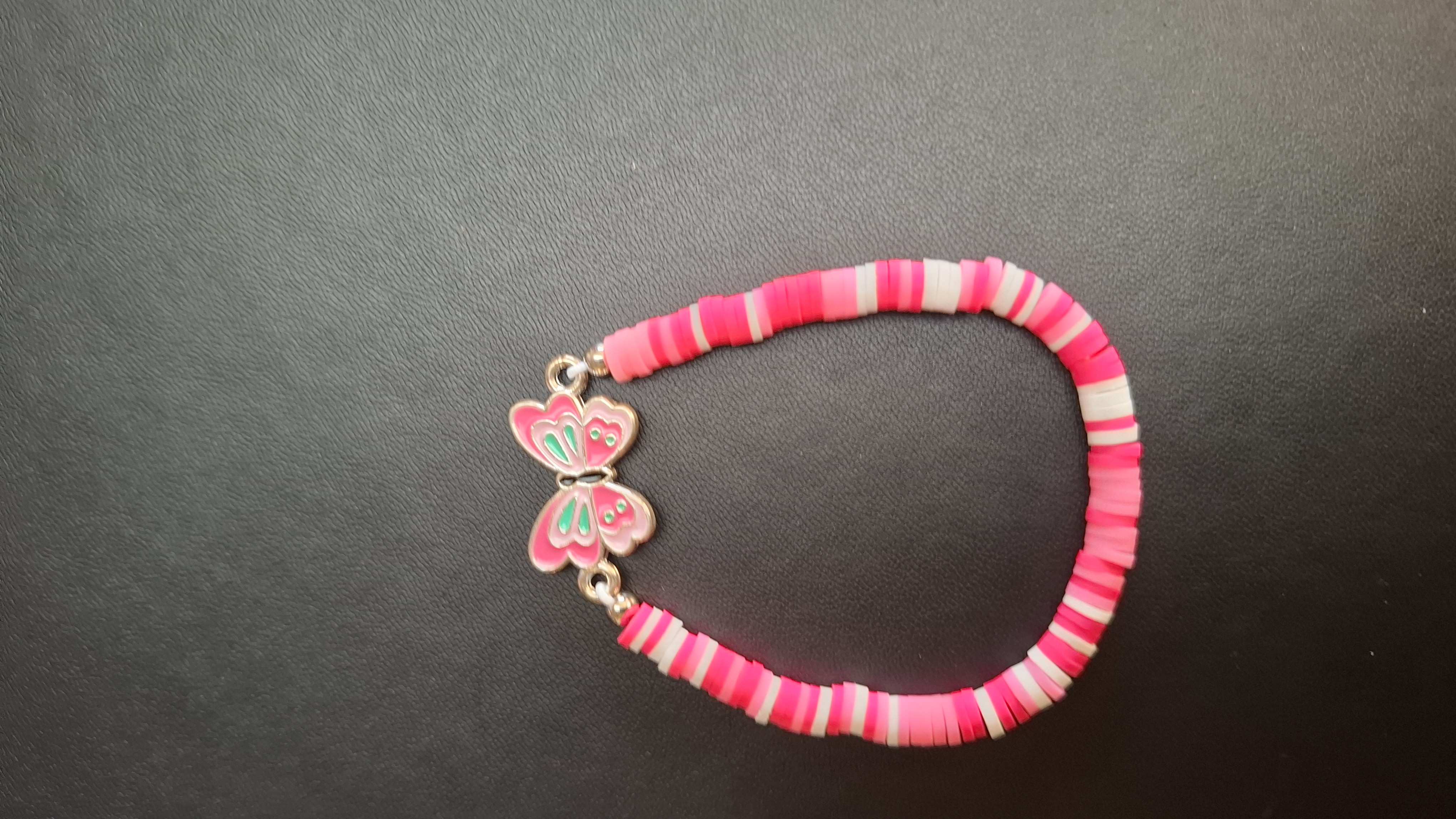 armband roze/wit met roze/turquoise vlinder