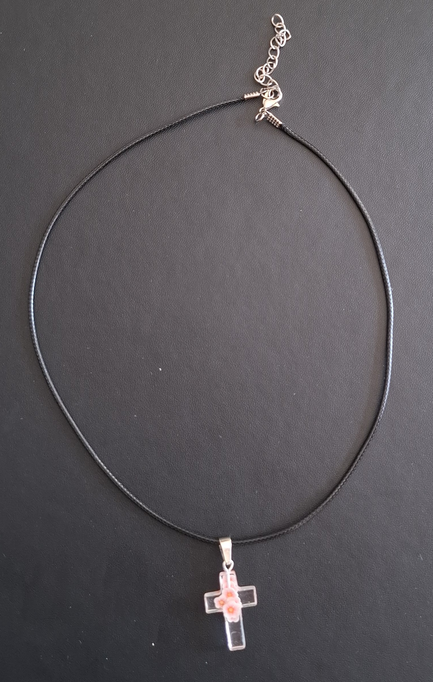 zwarte kunststof ketting met doorzichtig kruis met wit/rose/oranje bloemetjes 