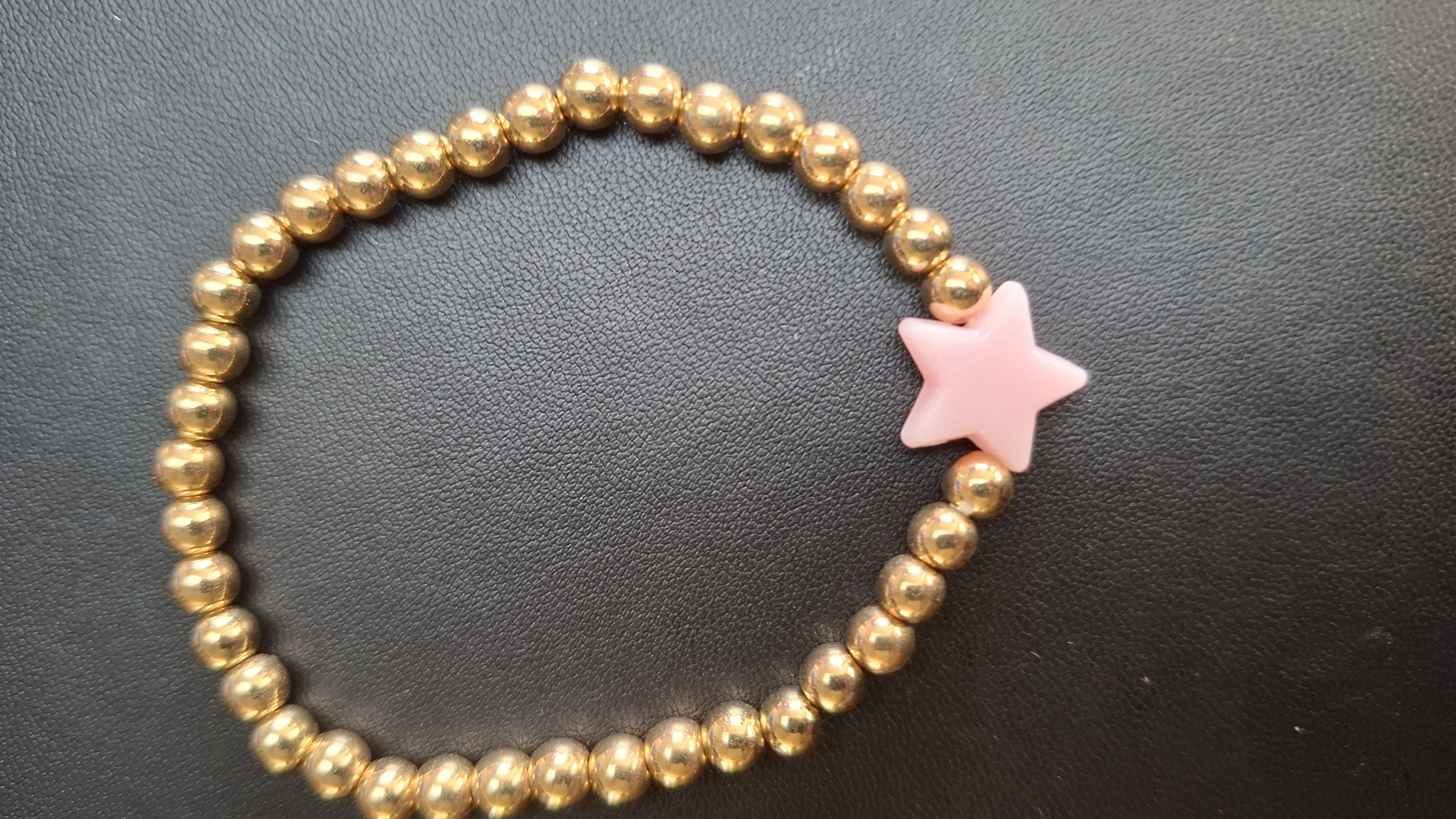 armband goud kleurige kralen met roze ster