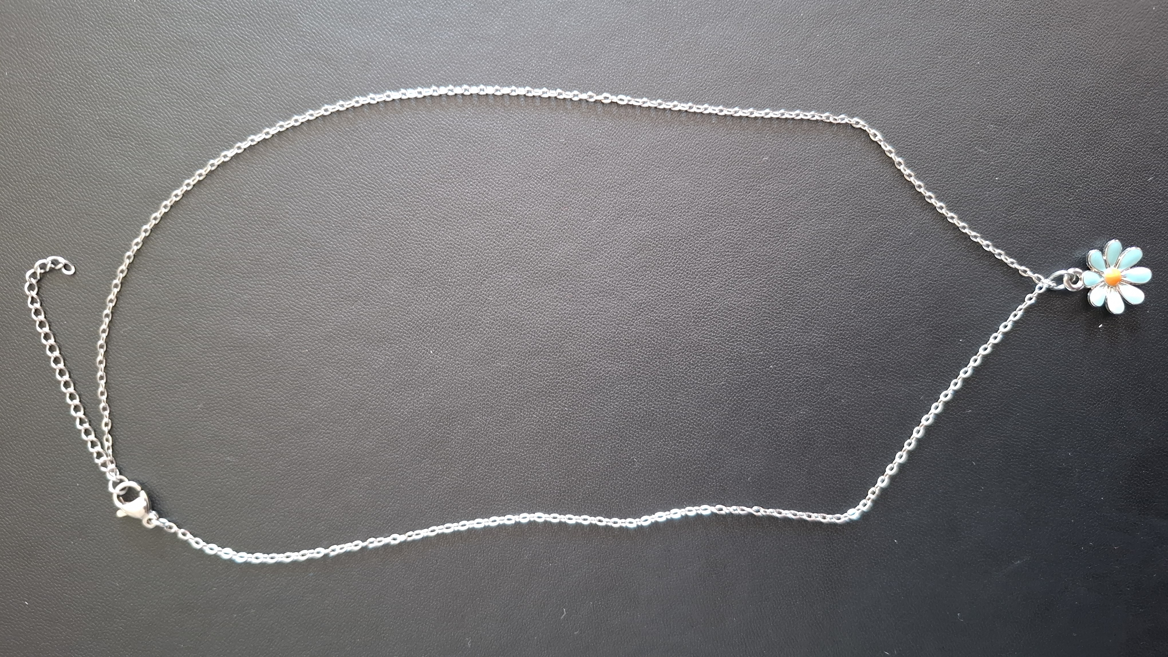 ketting in zilveren kleur met licht blauwe bloem