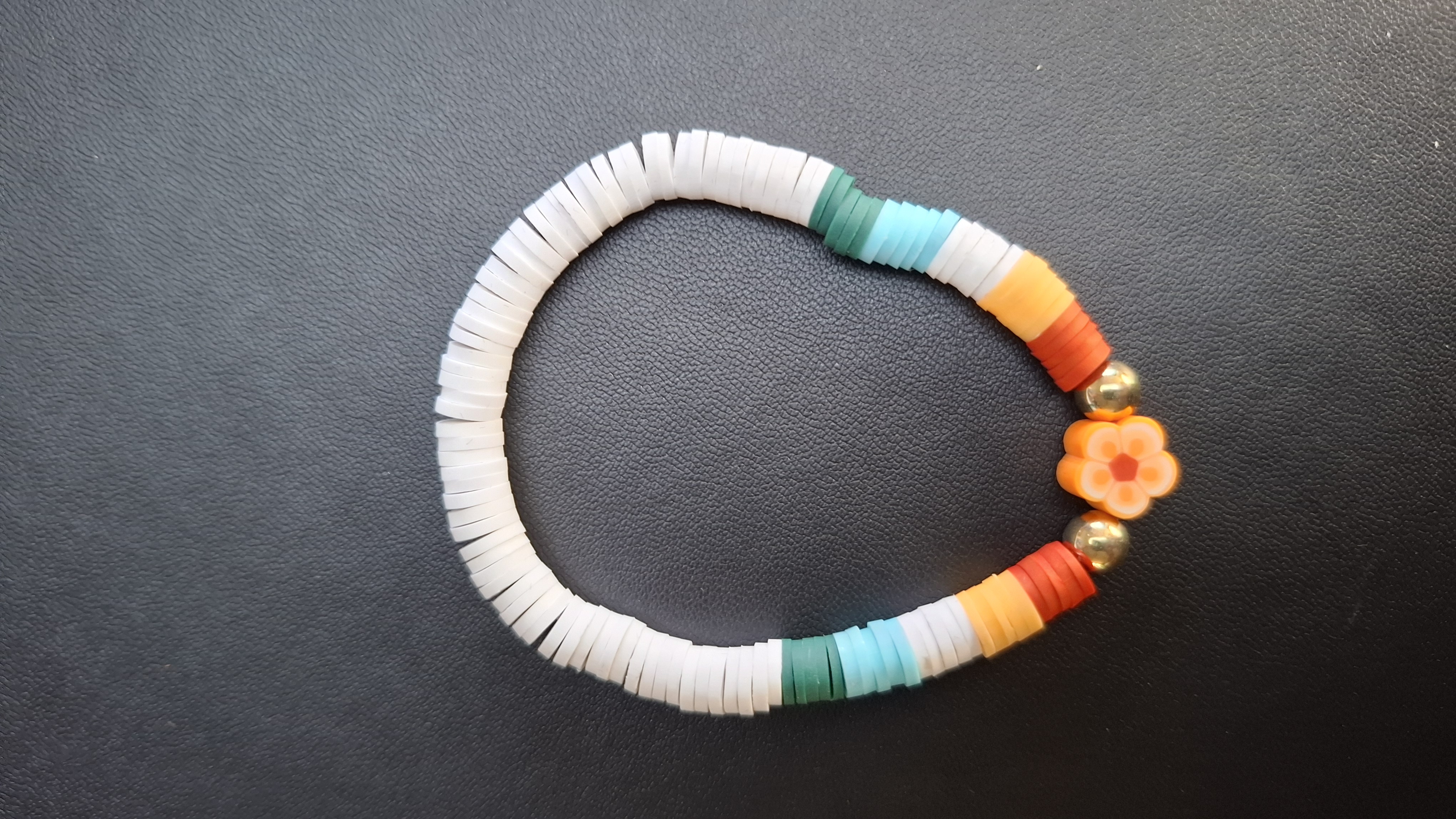 armband wit/groen/rood met oranje bloem