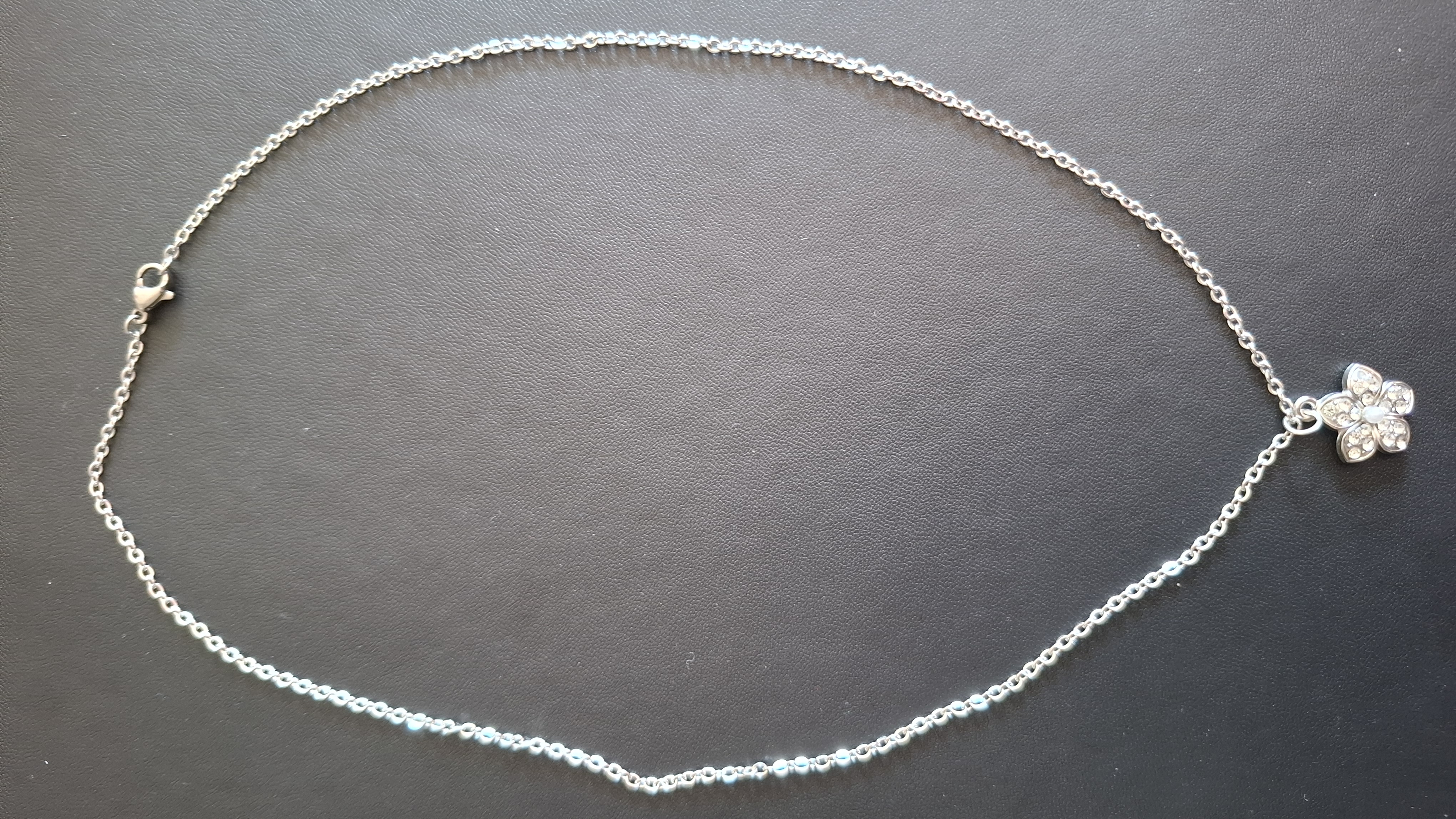 ketting in zilveren kleur met zilver kleurige bloem met steentjes