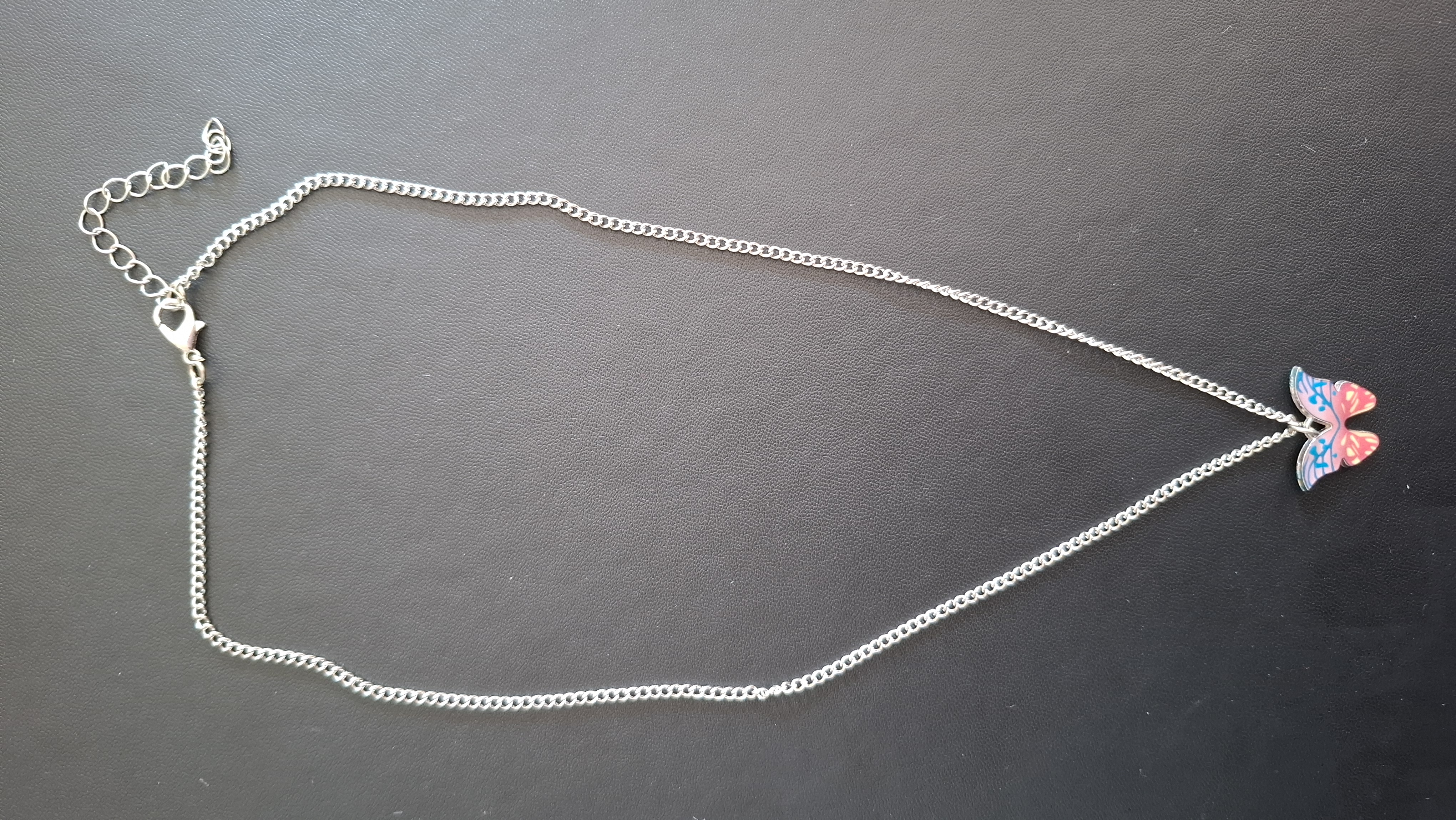 ketting in zilveren kleur met blauw/roze vlinder