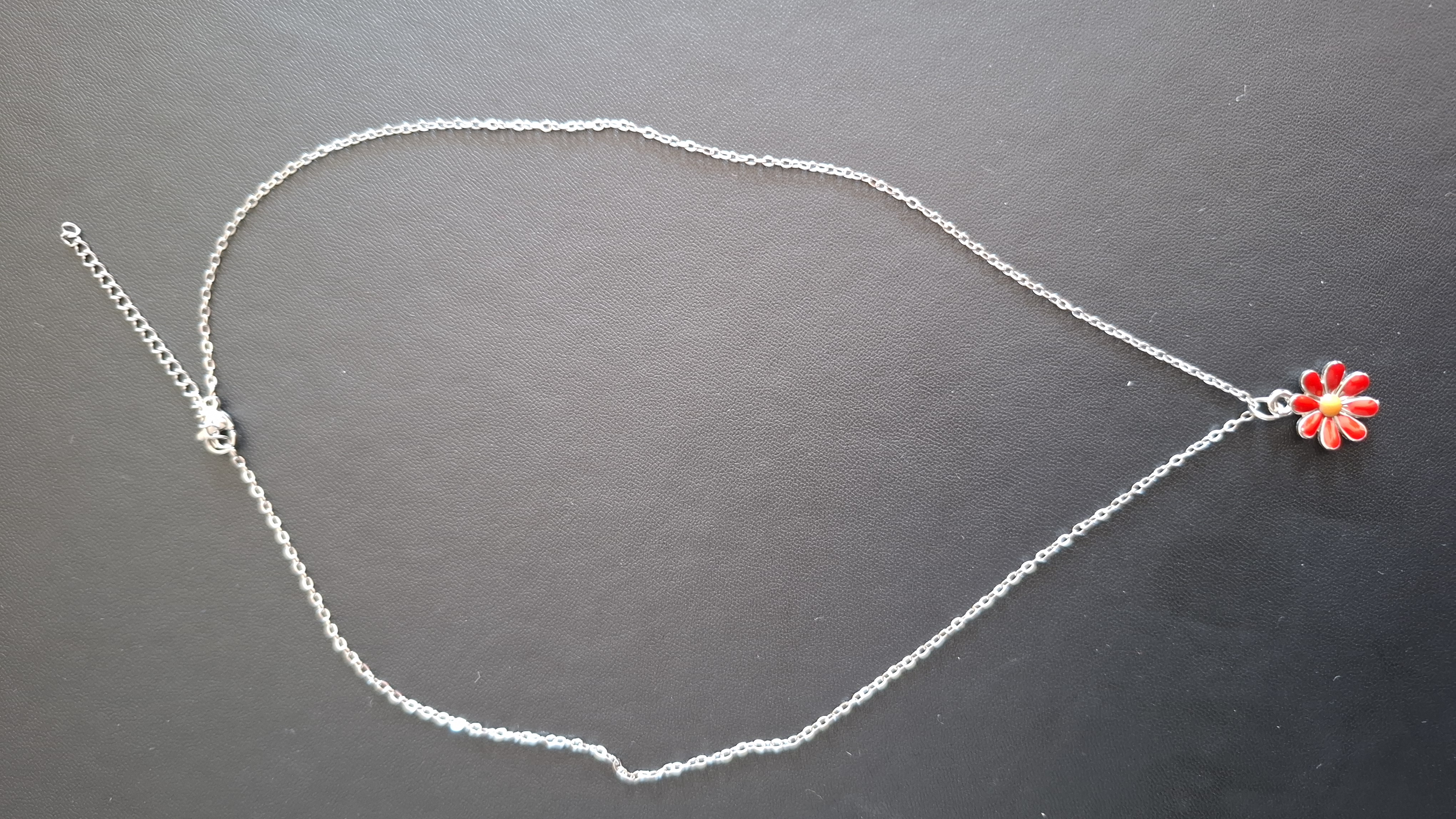 ketting in zilveren kleur met rode bloem