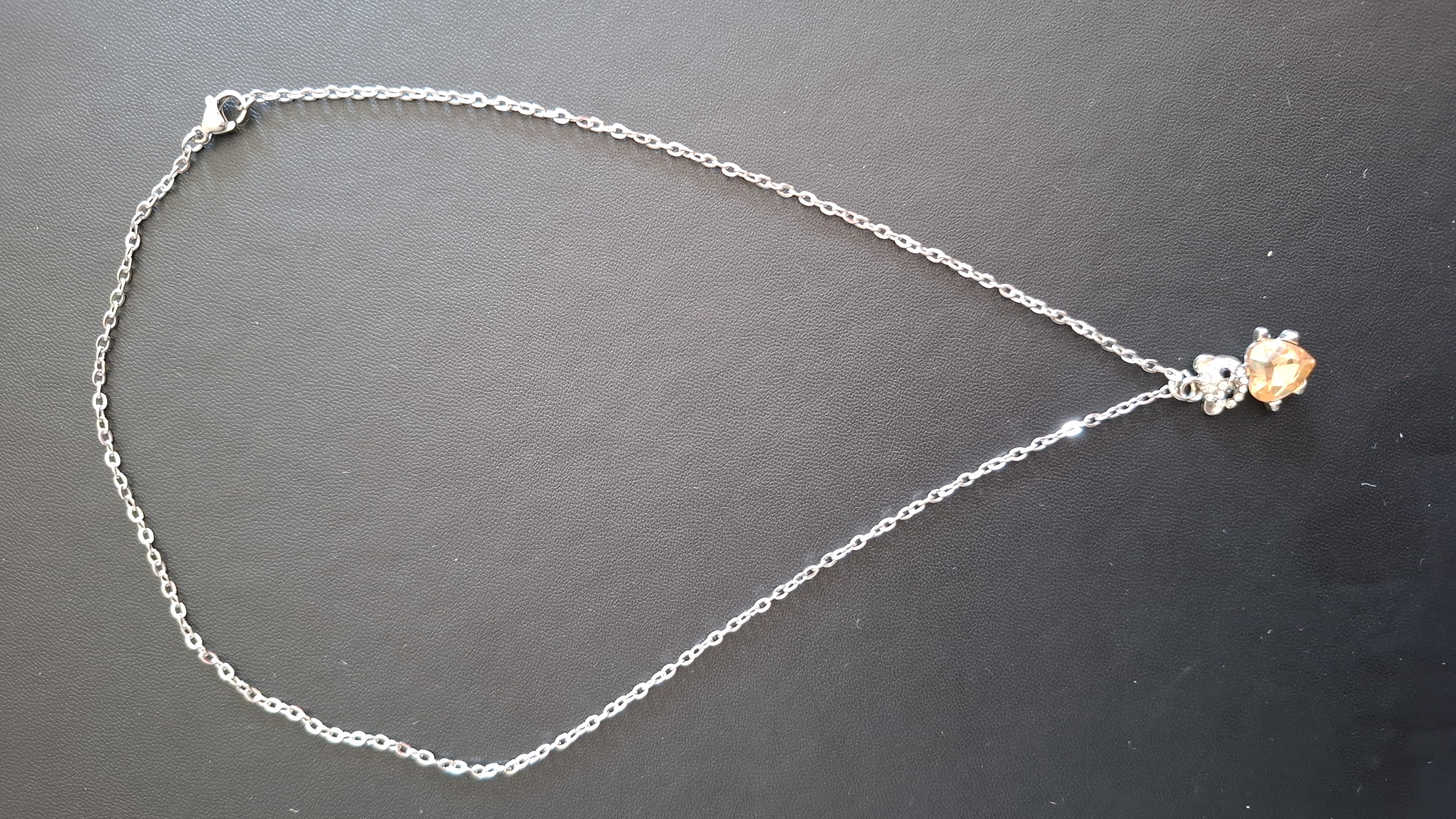 ketting in zilveren kleur met zilver kleurig beertje met oranje hartje