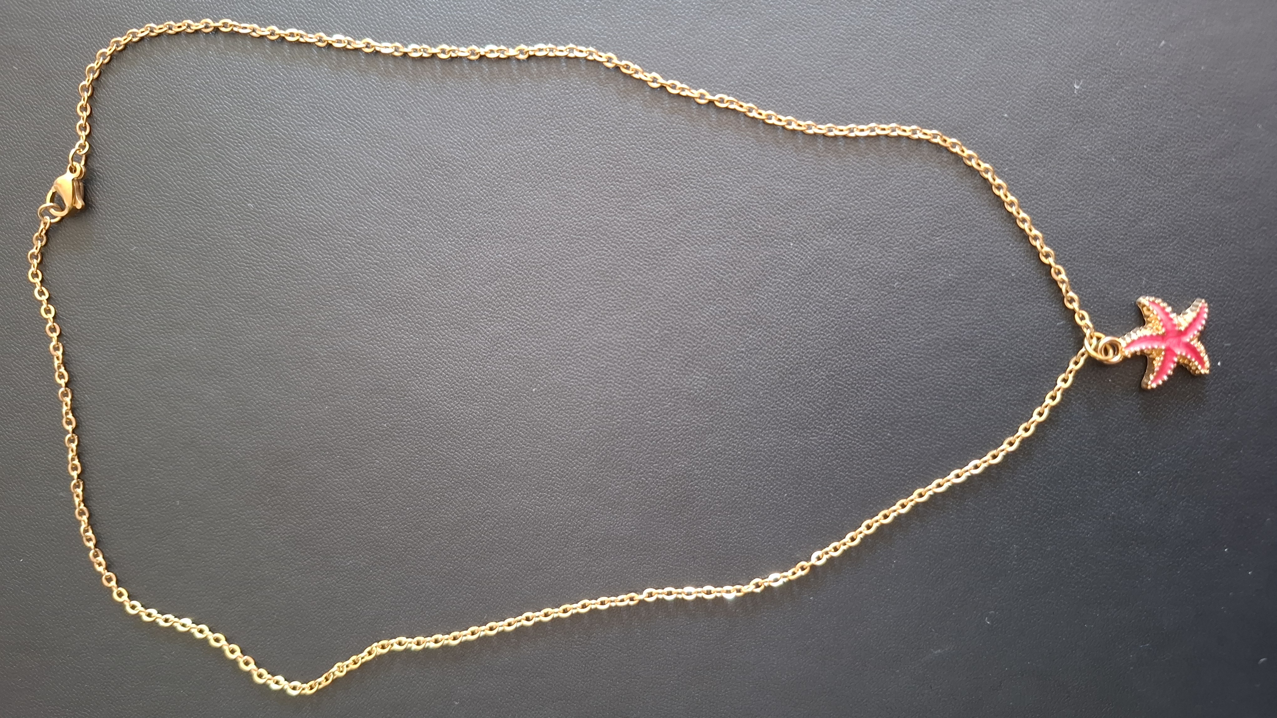 ketting in gouden kleur met roze/rode zeester